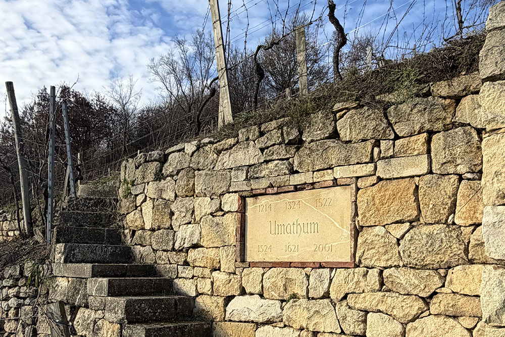 Alte Steinmauer mit Schild und Steintreppe